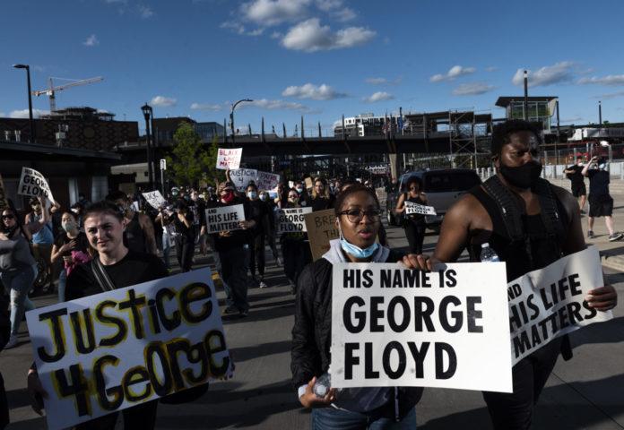 MINNEAPOLIS, MN - MAY 29: Protesters march by U.S. Bank Stadium in response to the police killing of George Floyd on May 29, 2020 in Minneapolis, Minnesota. Demonstrations and protests have been ongoing since Floyd's death in police custody on Monday. (Photo by Stephen Maturen/Getty Images)